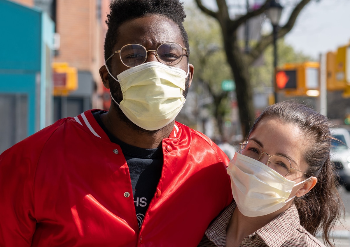 Two people wearing masks on street